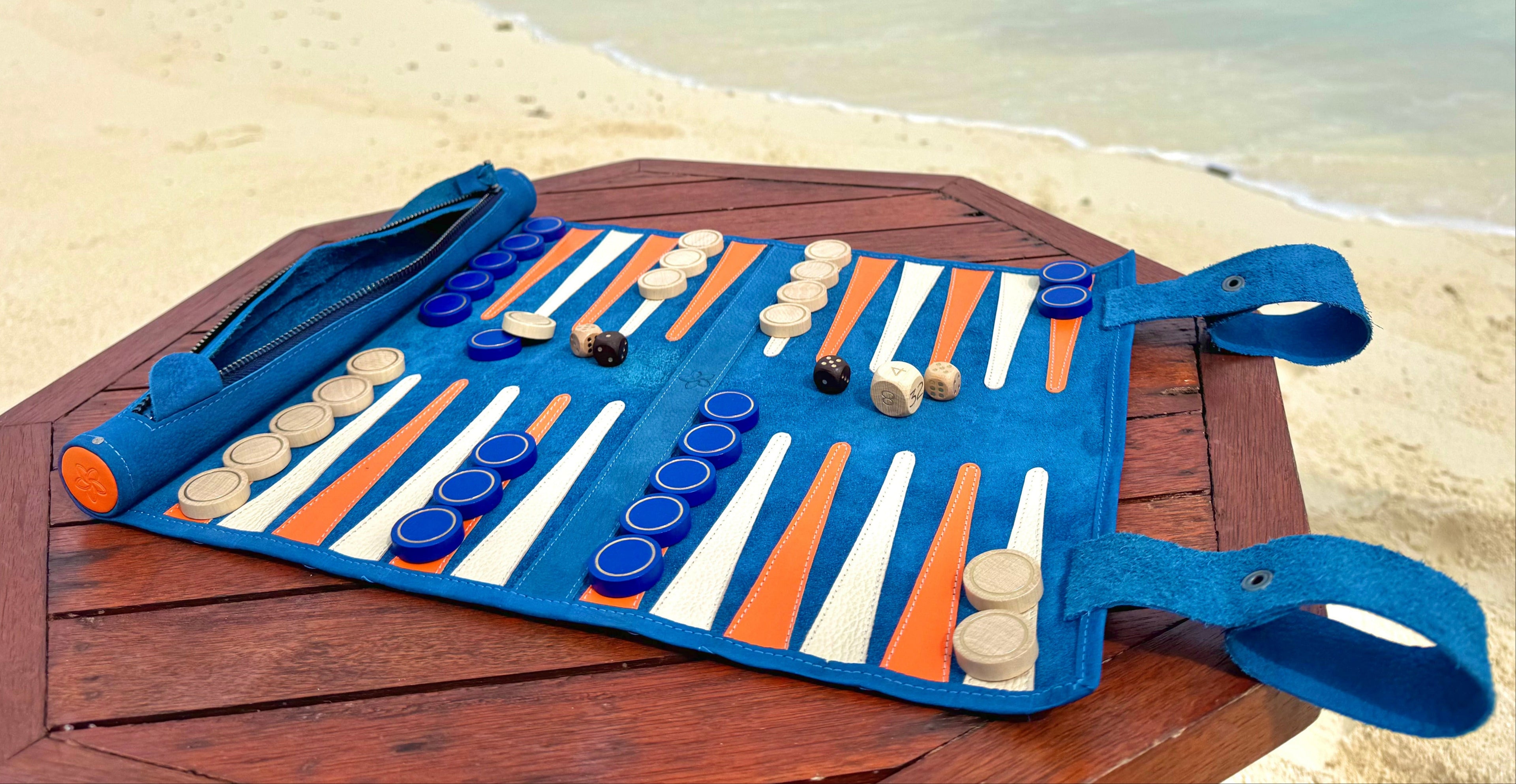 Backgammon set on a wooden table with a beach and ocean in the background