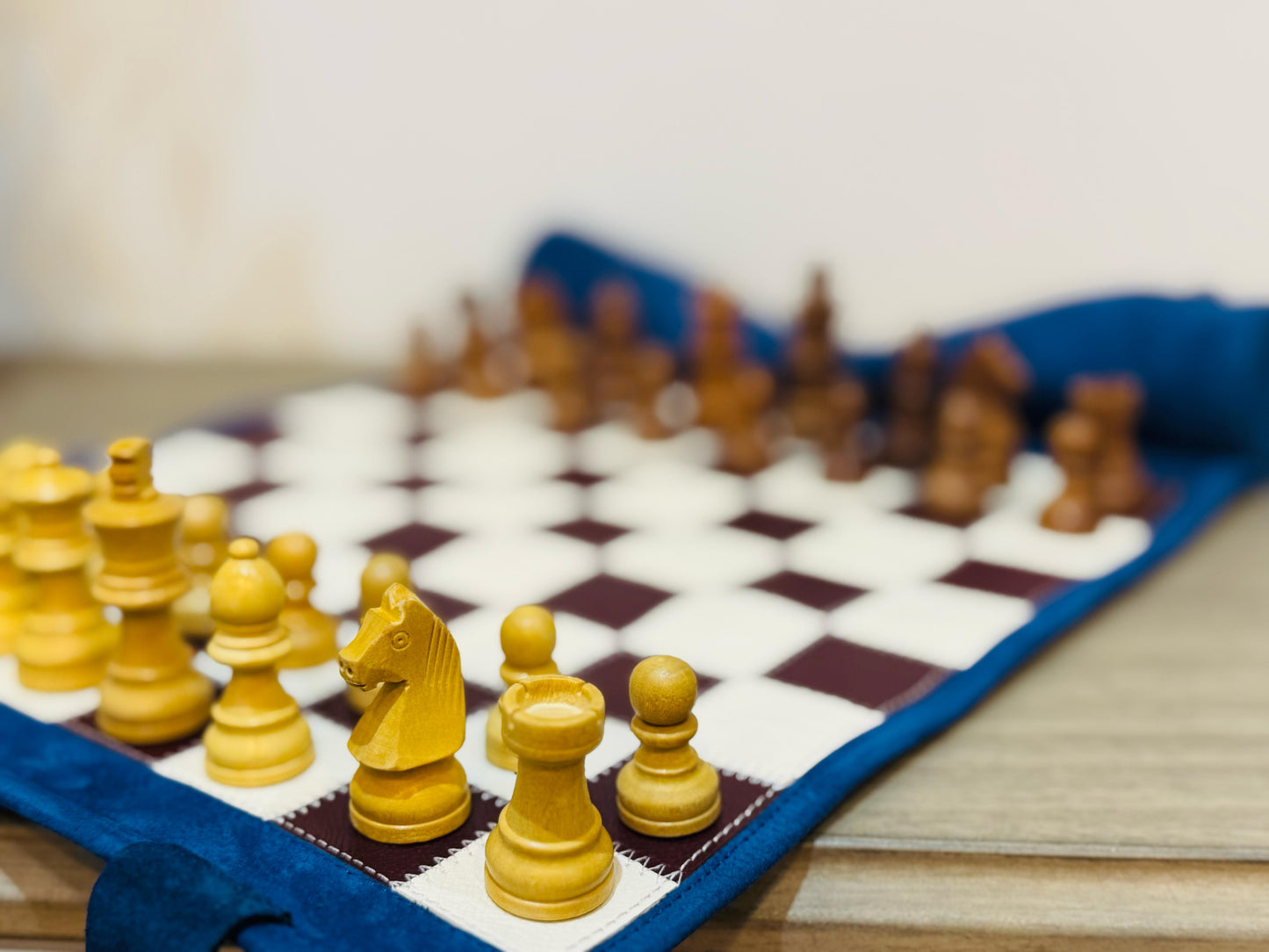 Close-up of burgundy magnetic chess pieces on the handcrafted leather board