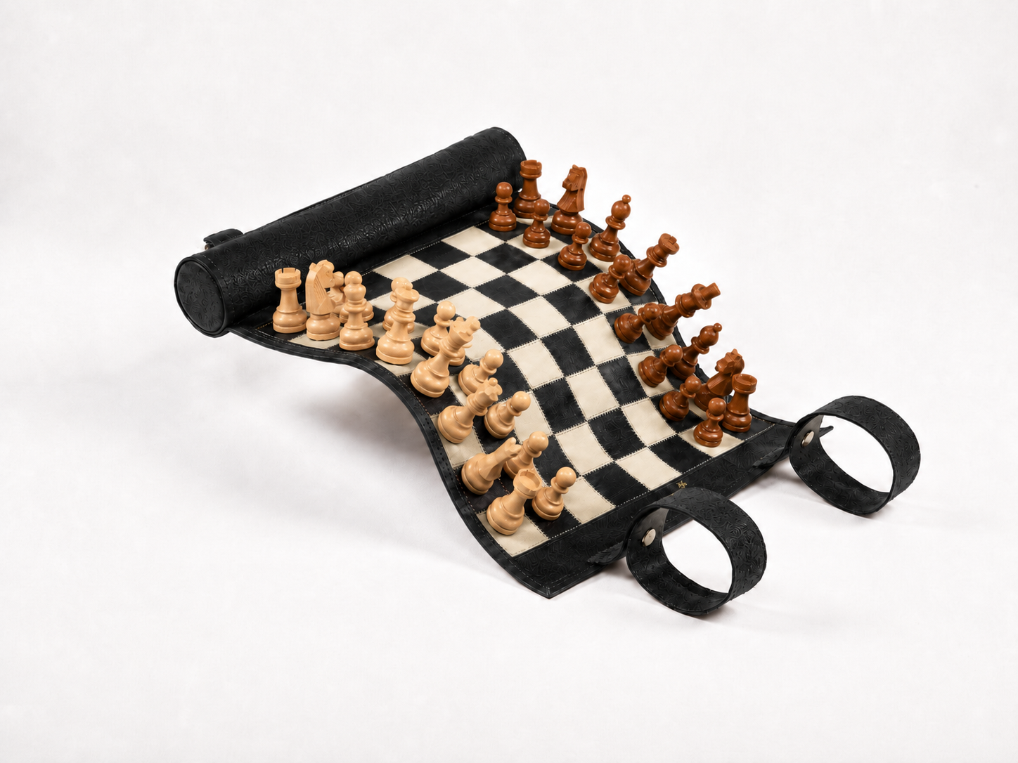 Luxury black leather magnetic chess set rolled open with handcrafted wooden chess pieces for travel and elegant play