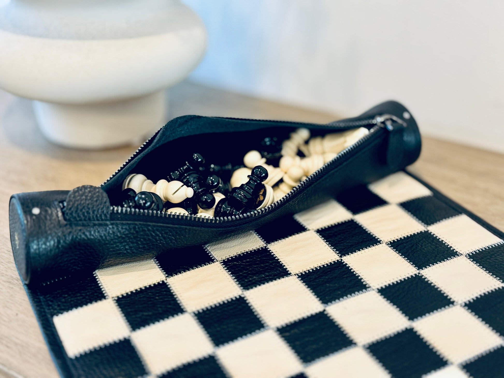 Luxury black leather chess board prepared for play with handcrafted magnetic chess pieces